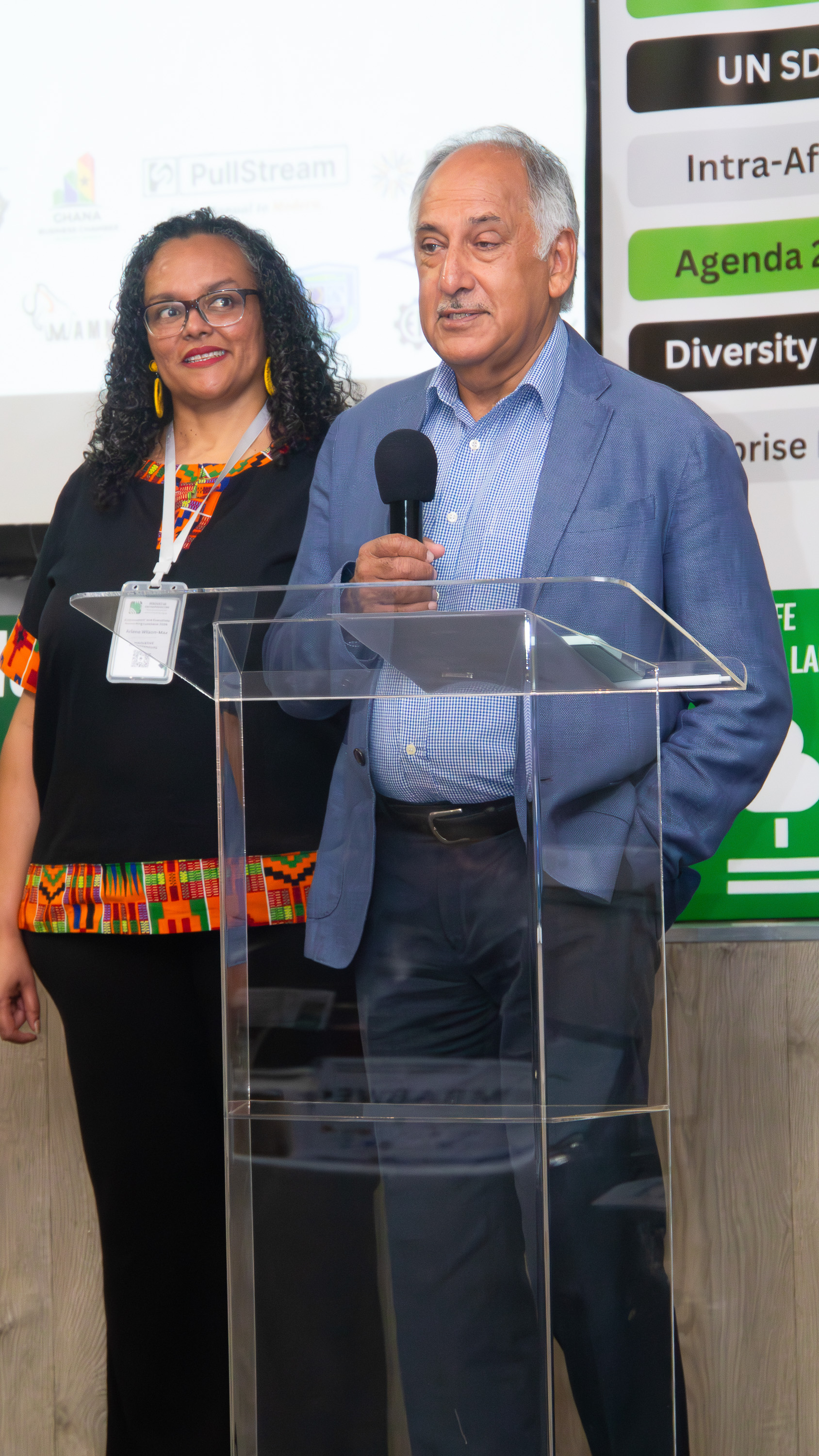 Programme Director Arlene Wilson-Max and a senior speaker address the Ambassadors' and Executives Networking Luncheon 2026 from the podium